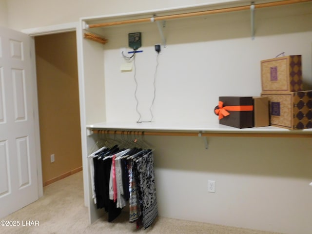 walk in closet featuring light colored carpet