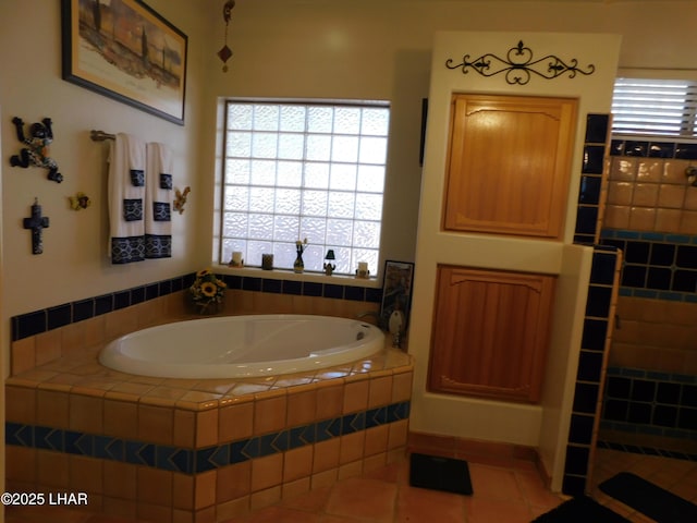 bathroom with tile patterned floors and tiled bath