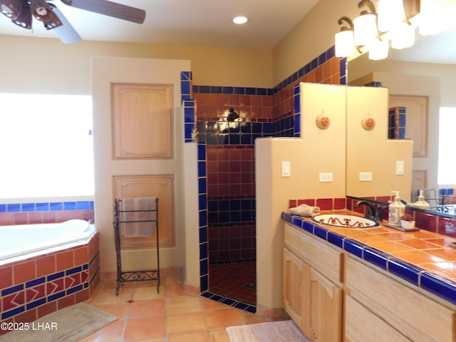 bathroom featuring tile patterned flooring, vanity, separate shower and tub, and ceiling fan with notable chandelier