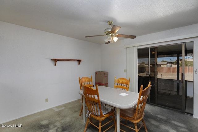 carpeted dining space with a textured ceiling and ceiling fan