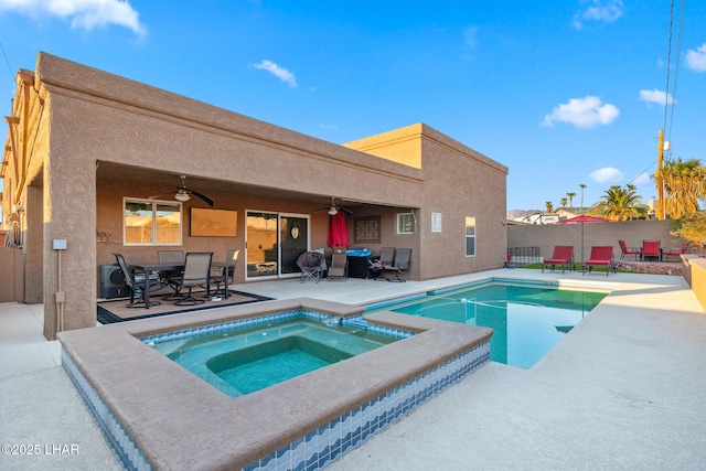 view of pool with an in ground hot tub, ceiling fan, and a patio area