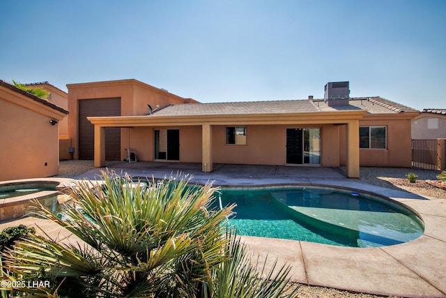 pool featuring a patio and an in ground hot tub