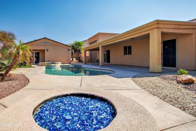 pool with a patio and an in ground hot tub