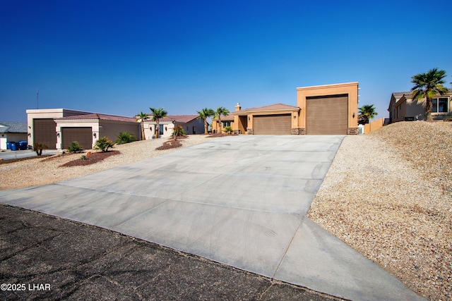 view of front of home with stucco siding, a garage, a residential view, stone siding, and driveway