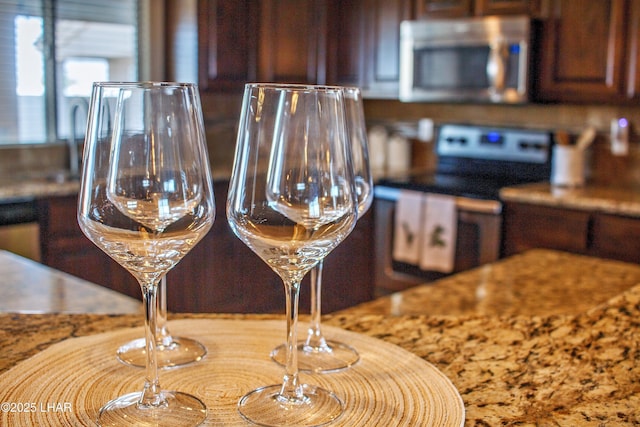 details with appliances with stainless steel finishes and stone countertops