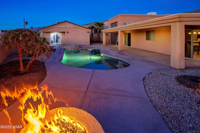 view of swimming pool featuring an outdoor fire pit, a pool with connected hot tub, and a patio