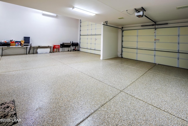 garage with a garage door opener and visible vents