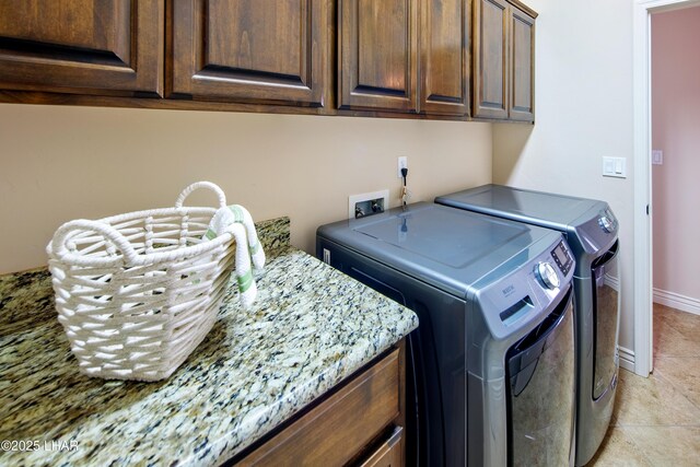 laundry room with light tile patterned floors, independent washer and dryer, cabinet space, and baseboards