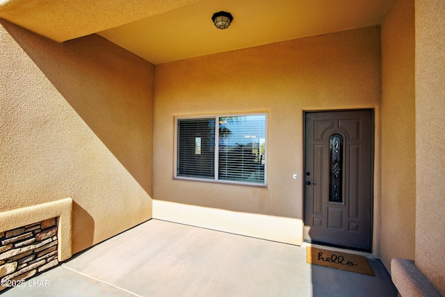 entrance to property featuring stucco siding