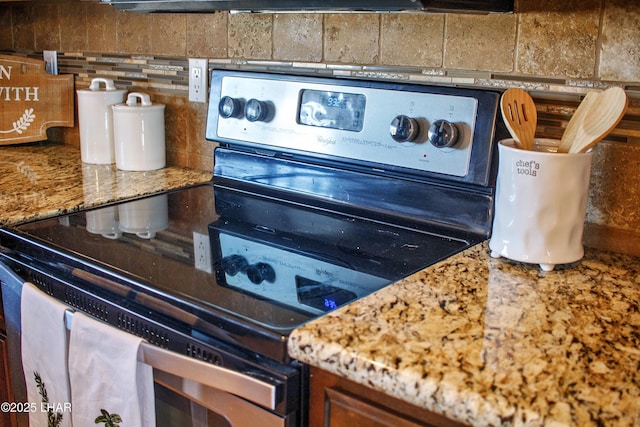 details featuring stainless steel electric stove and decorative backsplash