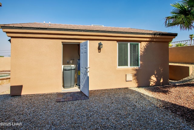 back of property featuring fence and stucco siding