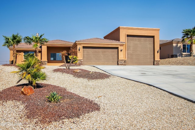 view of front of house featuring a garage, stone siding, driveway, and stucco siding