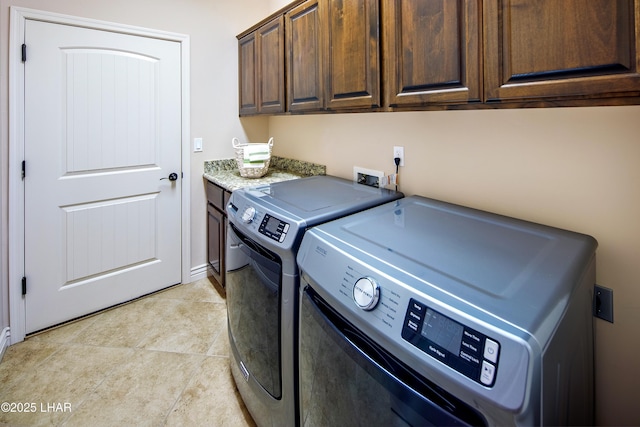 laundry area with cabinet space, independent washer and dryer, and light tile patterned floors