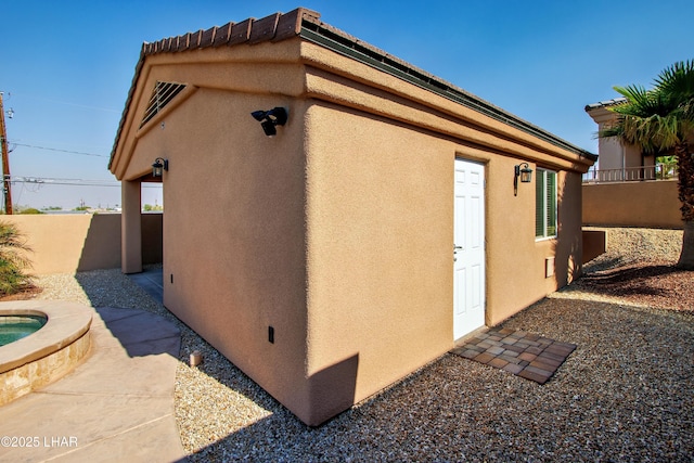 view of home's exterior with fence and stucco siding