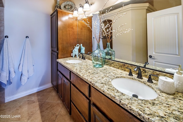 bathroom with double vanity, tile patterned flooring, a sink, and baseboards