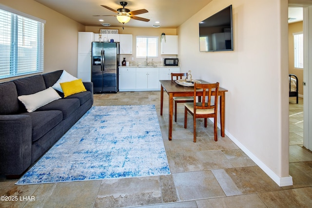 living area featuring recessed lighting, a ceiling fan, and baseboards