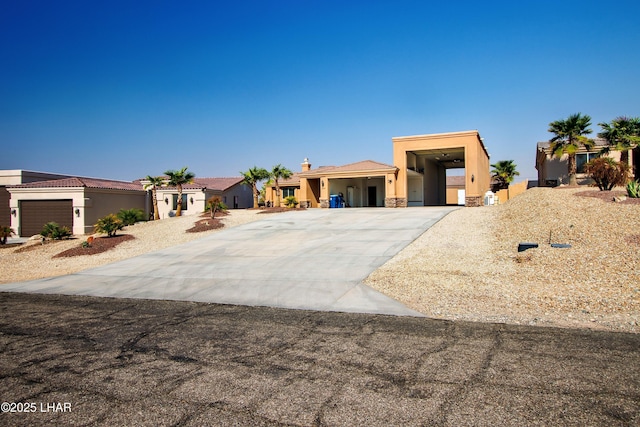 view of front of home featuring a residential view, stone siding, driveway, and stucco siding