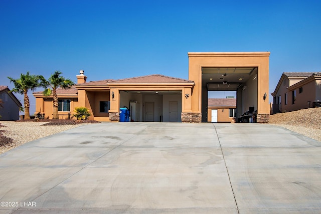 view of front of house with stone siding, concrete driveway, an attached garage, and stucco siding