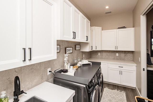 kitchen with sink, separate washer and dryer, dark hardwood / wood-style flooring, white cabinets, and backsplash