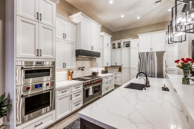 kitchen featuring white cabinetry, sink, stainless steel appliances, and light stone countertops