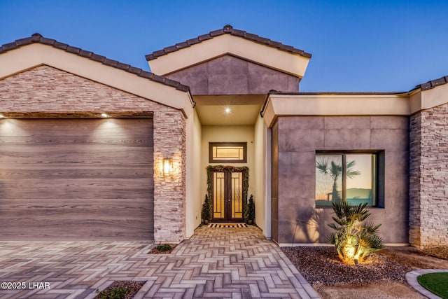 exterior entry at dusk featuring a garage