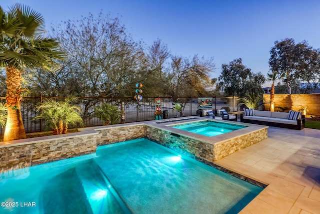 pool at dusk with an outdoor living space, an in ground hot tub, and a patio area