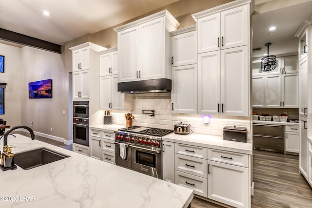 kitchen featuring appliances with stainless steel finishes, light stone countertops, sink, and white cabinets