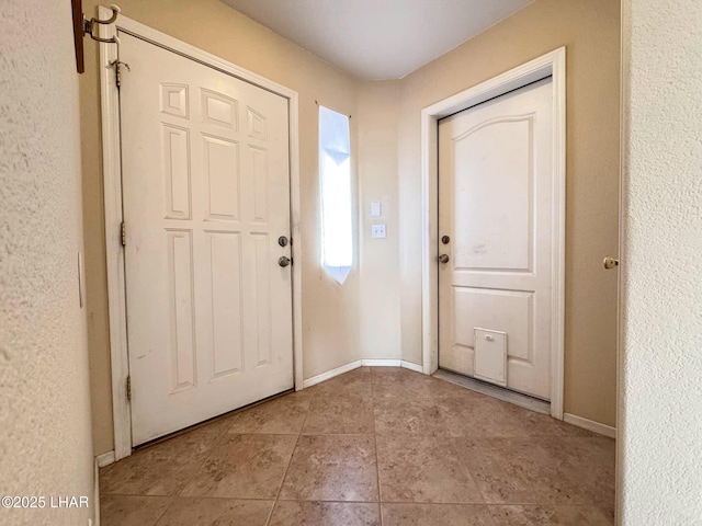 tiled entryway featuring baseboards