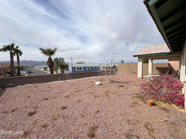 view of yard featuring a mountain view and a fenced backyard