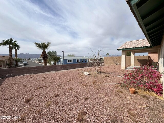 view of yard featuring a mountain view and a fenced backyard