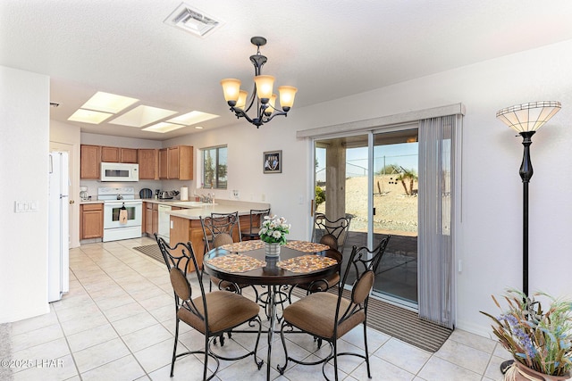 dining room with an inviting chandelier, sink, a textured ceiling, and light tile patterned flooring