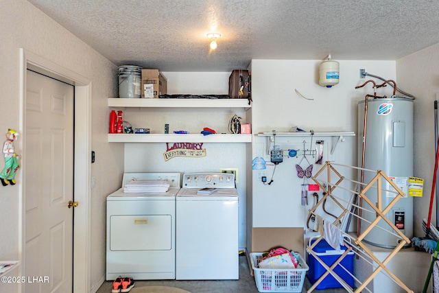 laundry area with washing machine and dryer, electric water heater, and a textured ceiling