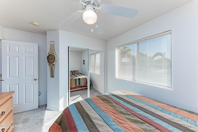 unfurnished bedroom with light carpet, a closet, and ceiling fan