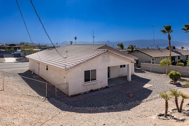 rear view of property featuring a mountain view and a patio area