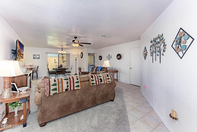 tiled living room featuring ceiling fan with notable chandelier and a textured ceiling