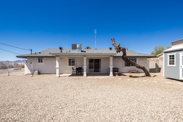 2130 Smoketree Ave N, Lake Havasu City, AZ 86403 - back of property featuring an outdoor structure, stucco siding, fence, central AC, and a patio area
