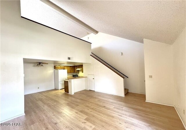 empty room with lofted ceiling, carpet flooring, and a textured ceiling