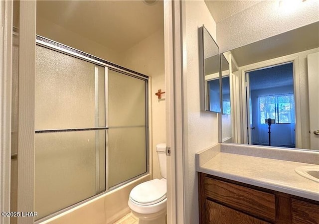 full bathroom featuring vanity, toilet, and combined bath / shower with glass door