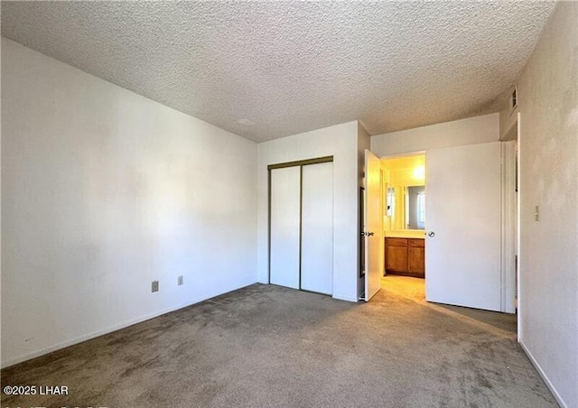 unfurnished bedroom with light colored carpet, a closet, and a textured ceiling