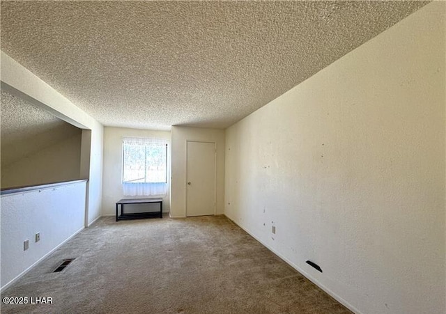 empty room with a textured ceiling and carpet