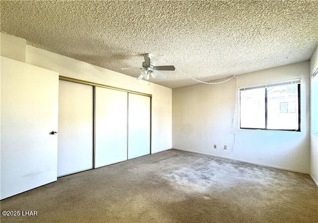 unfurnished bedroom featuring ceiling fan, carpet floors, a closet, and a textured ceiling