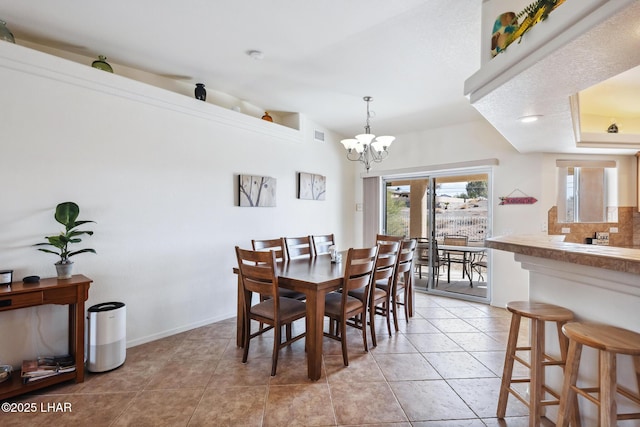 dining space featuring an inviting chandelier, baseboards, and light tile patterned flooring