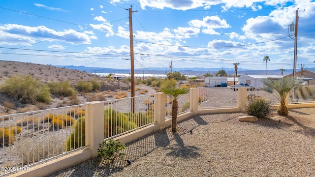 view of yard featuring fence and a mountain view