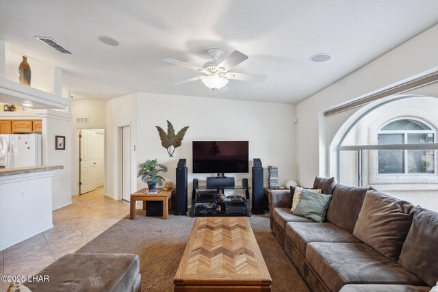 living area with light tile patterned floors, visible vents, and a ceiling fan