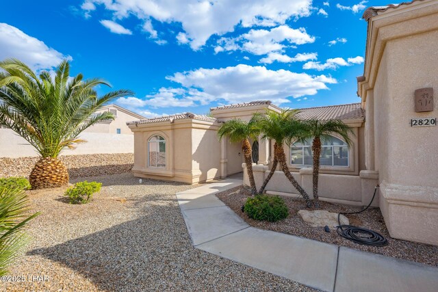 view of front of house featuring a tiled roof and stucco siding