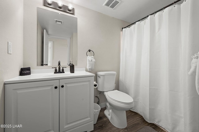 bathroom with visible vents, wood finished floors, toilet, and vanity