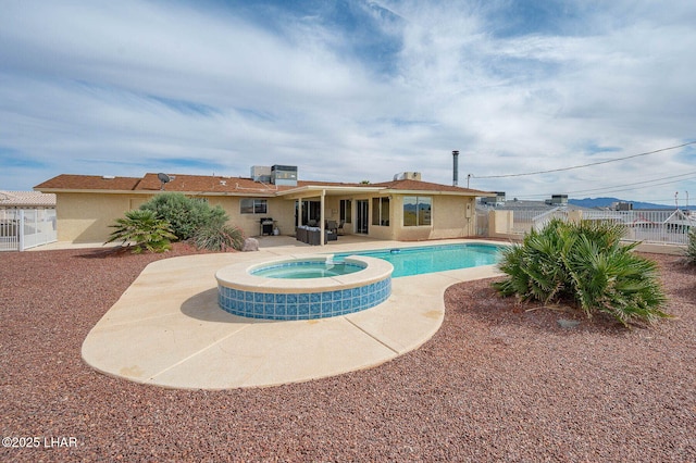 view of swimming pool featuring a pool with connected hot tub, fence, and a patio area
