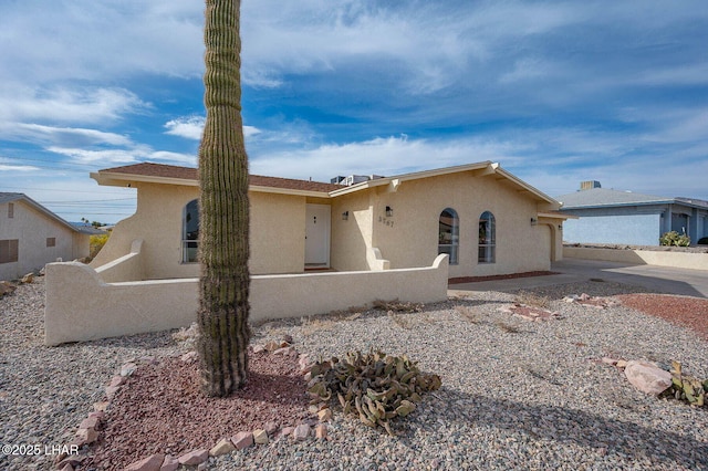 ranch-style house with fence and stucco siding