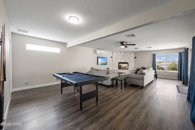 playroom with an AC wall unit, ceiling fan, visible vents, and dark wood finished floors