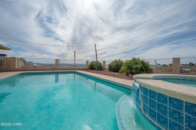 view of swimming pool with fence and a pool with connected hot tub